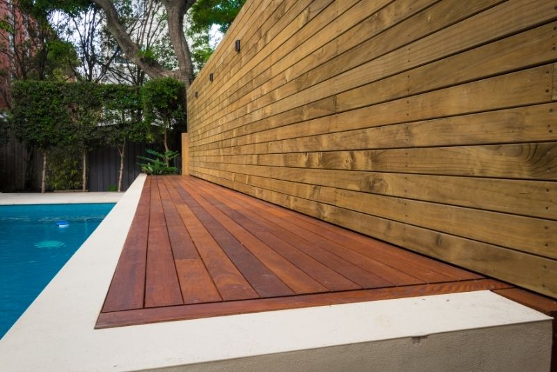 wooden deck on the side of the pool area
