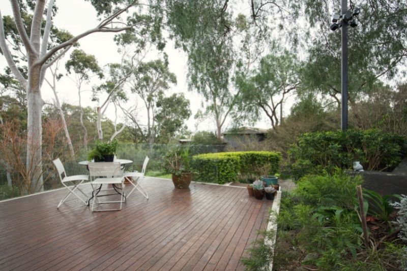 stunning patio decking space sorrounded with plants and trees