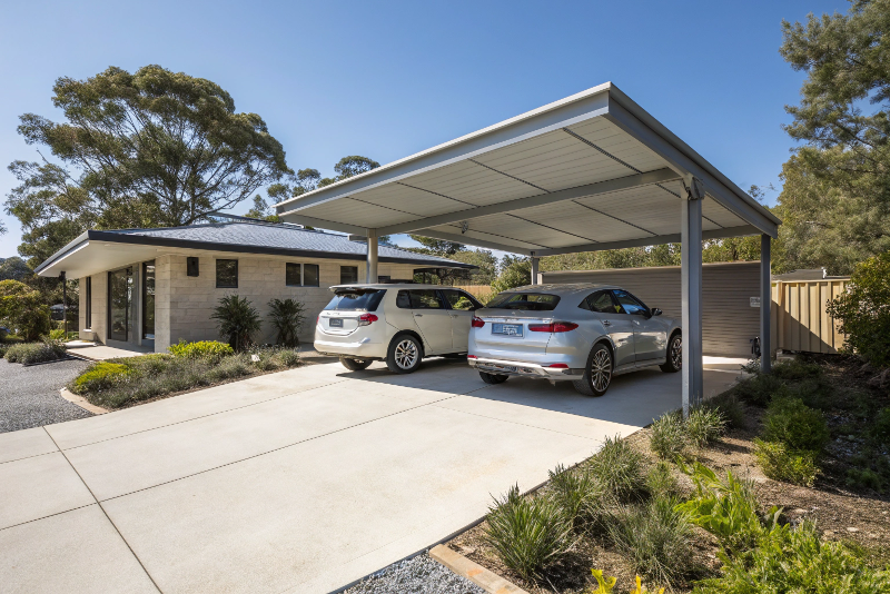 Modern double carport with Colorbond roof attached to contemporary home in Canberra with two cars parked underneath